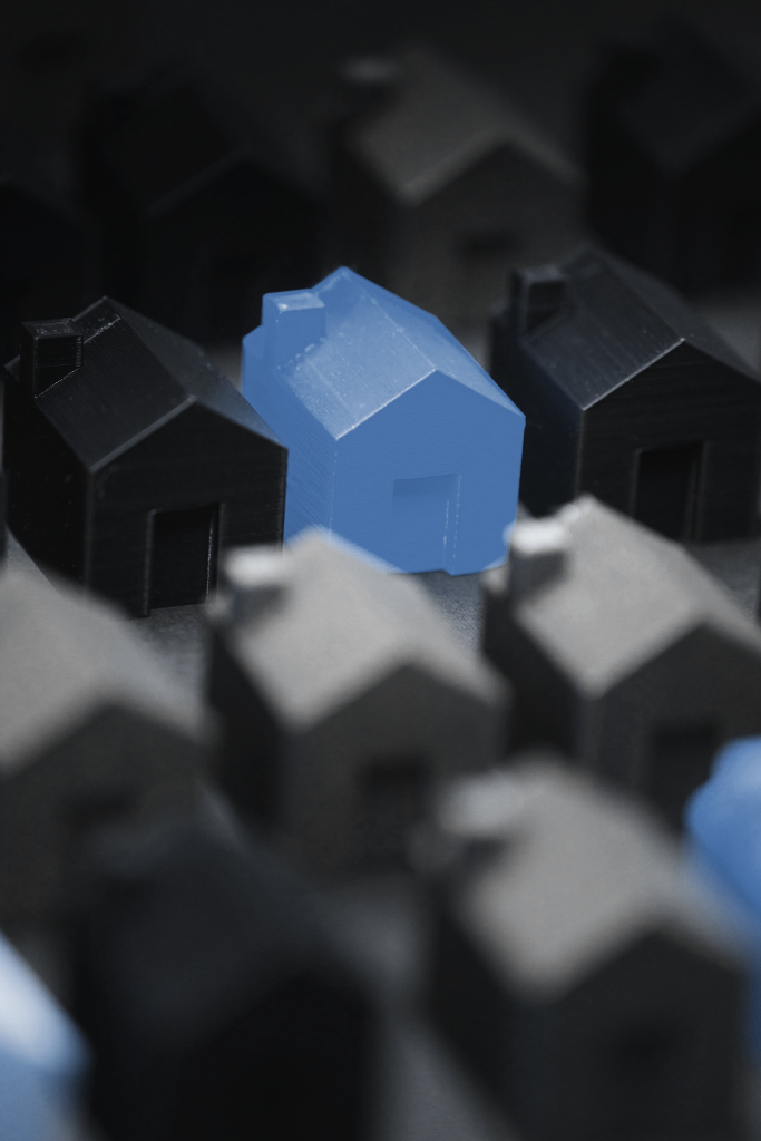 Blaues Miniaturhaus inmitten von grauen und schwarzen Miniaturhäusern | Foto von © Jakub Zerdzicki